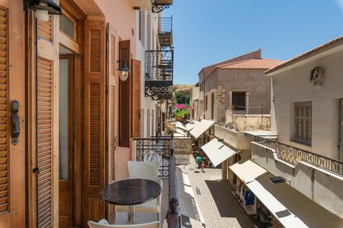 a balcony with a table and chairs on a city street at Narkissos 'SUPERB' in Chania Town