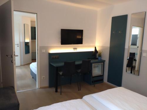 a room with a desk with a television and a bed at Pension Elisabeth - Rooms & Apartments in Salzburg