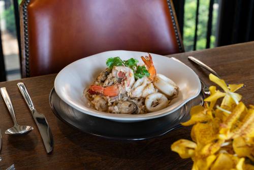 a bowl of food on a table with french fries at The Siam in Bangkok