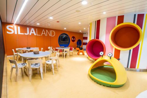 a restaurant with tables and chairs and a slide at Tallink Silja Line Ferry - Helsinki to Stockholm in Helsinki