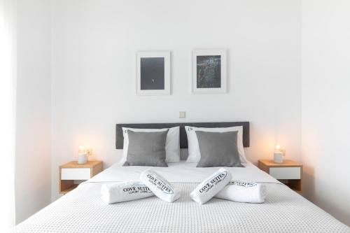 a white bed with two white pillows on it at Cove Suites Apartment in Iraklitsa