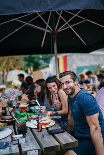 a group of people sitting at a table under an umbrella at Green Fields - Durbuy in Durbuy
