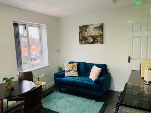 a living room with a blue couch and a table at Modern & Cosy 2-Bed Apartment Near NEC, Airport & JLR! in Birmingham