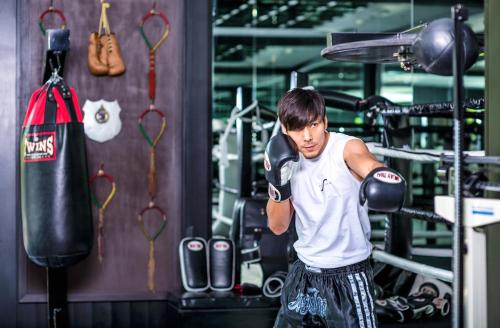 a young man wearing boxing gloves in a gym at The Siam in Bangkok