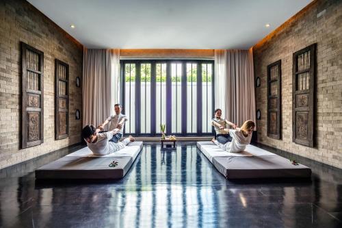 a group of people sitting on beds in a pool at The Siam in Bangkok