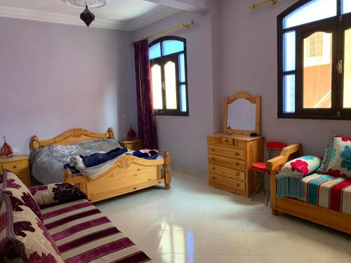 een slaapkamer met 2 bedden, een dressoir en een spiegel bij Dar Amallay in Tamraght Ou Fella