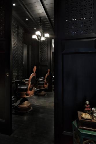 a dark room with a row of chairs and tables at The Siam in Bangkok