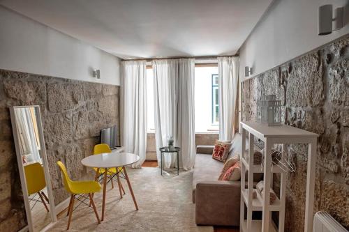 ein Wohnzimmer mit einem Tisch und gelben Stühlen in der Unterkunft Try Oporto - Ribeira in Porto