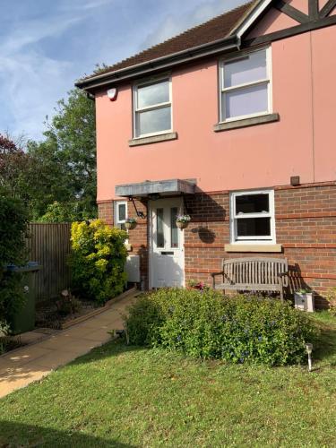 a pink house with a bench in the yard at Yew Tree House in Arundel