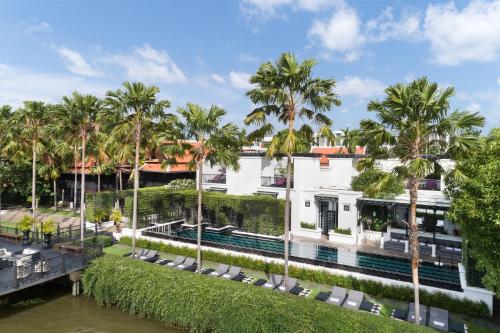 an exterior view of a building with palm trees at The Siam in Bangkok