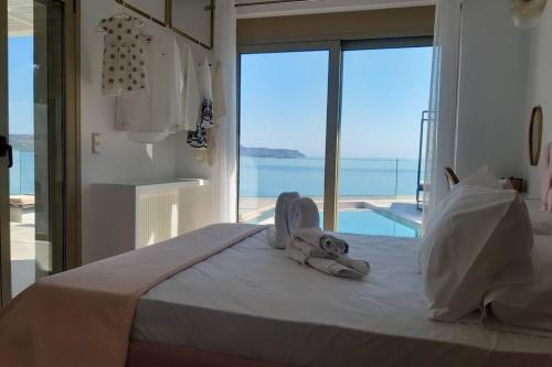 a bedroom with a bed with a view of the ocean at Luxury Villa Dioskouroi eco pool & jacuzzi Kalyves in Kalyves