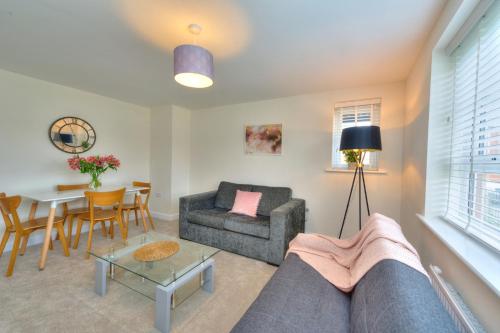 a living room with a couch and a table at Executive Fairfields Apartment by PAY AS U STAY in Milton Keynes