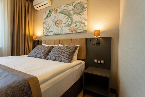 a hotel room with a bed and a painting on the wall at Levor Hotel in Bursa