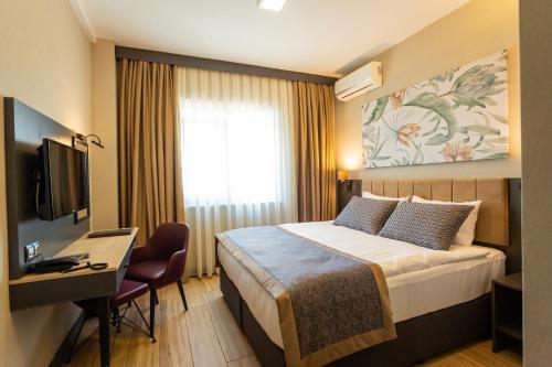 a hotel room with a bed and a desk and a television at Levor Hotel in Bursa