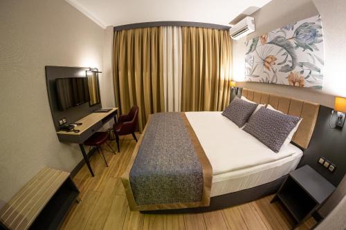 a hotel room with a bed and a desk and a television at Levor Hotel in Bursa