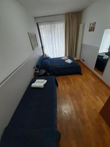 a small room with two beds and a window at MATISSE 2 in Bergamo