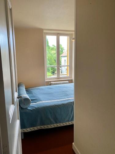a bedroom with a bed and a window at Hôtel de famille L.F.M.A.L. in Giat