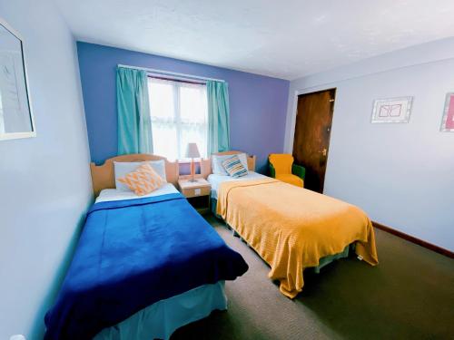a blue room with two beds and a window at Redwings Lodge Sawtry Huntington in Sawtry