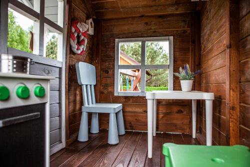 a kitchen with a table and a window in a cabin at Dom Wakacyjny Premium Bory Tucholskie - WiFi kominek sauna jacuzzi Smart TV in Męcikał