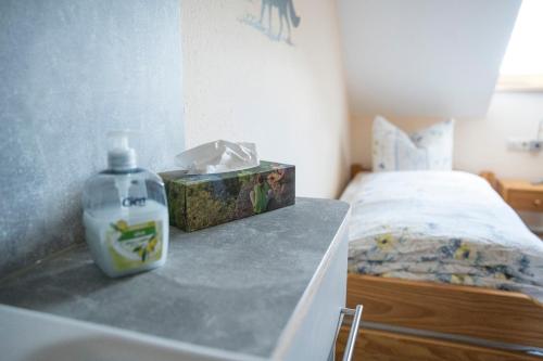 a bottle of soap sitting on a counter next to a bed at Gasthaus & Pension Am Rennsteig in Spechtsbrunn