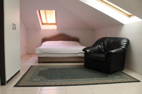 a bedroom with a bed and a leather chair at Villa Čengić in Sarajevo