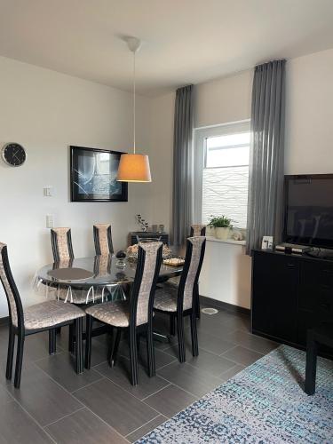a dining room with a table and chairs and a television at An der Wurzel in Germeter