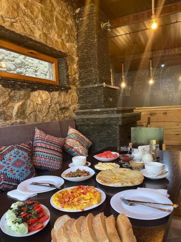 a table with many plates of food on it at Guest House Nikala in Mestia