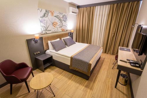 a small hotel room with a bed and a television at Levor Hotel in Bursa