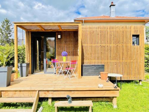 Casa con terraza de madera con mesa y sillas en Cabane de Rafael, en Vittel