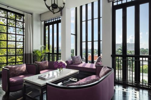a living room with purple furniture and large windows at The Siam in Bangkok
