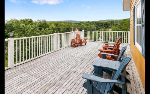 a deck with chairs and tables on a house at The Island Inn in Ingonish Beach