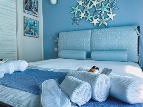 a blue bedroom with a large bed with towels on it at Las Floridas Apartment in Alghero