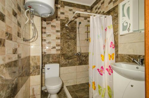 een badkamer met een toilet, een wastafel en een douche bij Apartment Sanik in Varna