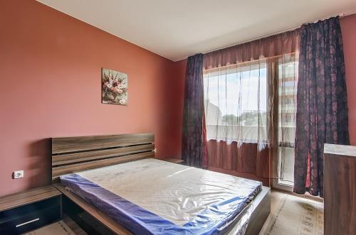 1 dormitorio con cama y ventana en Apartment Sanik, en Varna