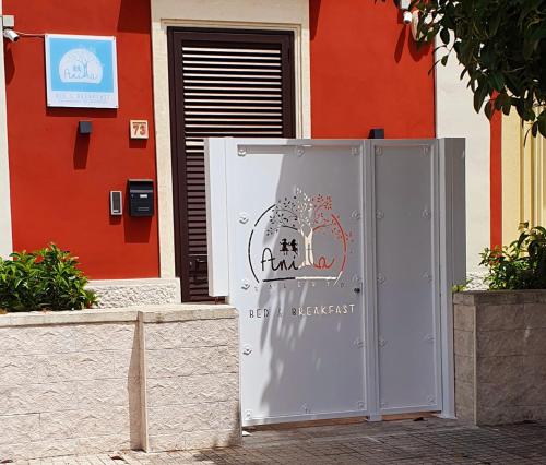 a gray refrigerator in front of a red building at B&B Casa di Anita in Arnesano