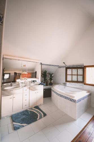 La salle de bains est pourvue d'une baignoire et de 2 lavabos. dans l'établissement Chez Fred et Cécile, à Verdilly