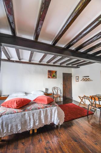 - une chambre avec un lit doté d'oreillers rouges dans l'établissement Chez Fred et Cécile, à Verdilly