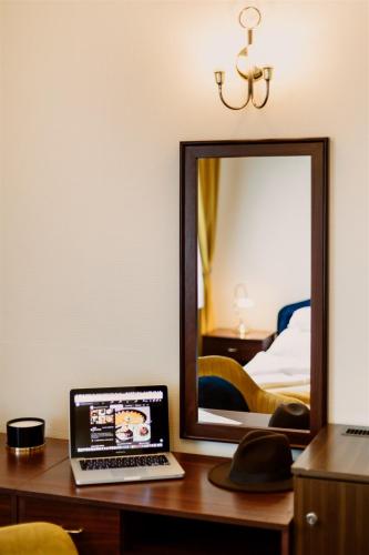 a laptop computer sitting on a desk in front of a mirror at Korona Pension and Restaurant in Hévíz