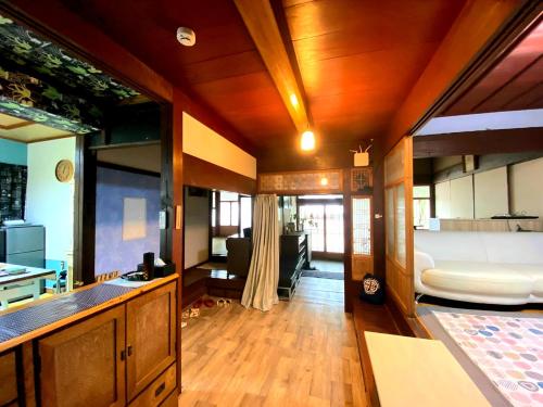 a kitchen and living room with a bed and a couch at Guesthouse Tao in Tanabe