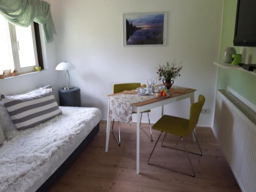 ein Wohnzimmer mit einem Tisch und einem Stuhl in der Unterkunft Villa Sonja in Kurort Altenberg
