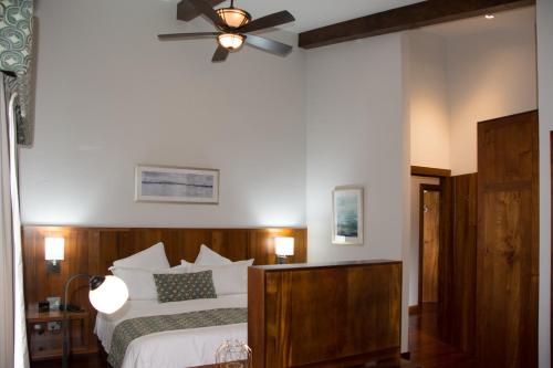 a bedroom with a bed and a ceiling fan at Los Brezos Hotel Boutique in Volcán