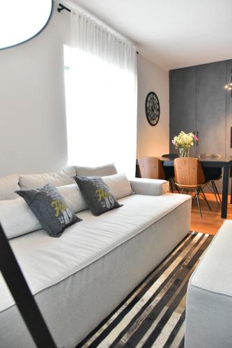 a living room with a white couch with pillows at Lux Luna apartments & rooms Old town in Zadar