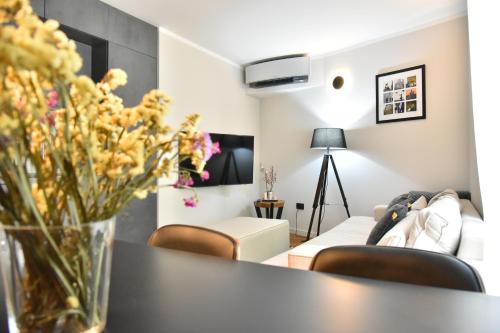 a living room with a table with a vase of flowers at Lux Luna apartments & rooms Old town in Zadar