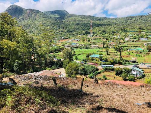 a village in a valley with mountains in the background at Miliya Guest House in Nuwara Eliya