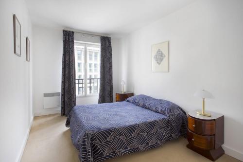 um quarto com uma cama e uma janela em Chuquet par Locappart - Lumineux & Art Deco em Paris