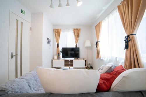 a living room with a white couch and a tv at Skytree view Oshiage in Tokyo