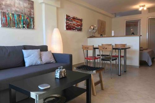 salon z kanapą i stołem w obiekcie Cozy seafront loft - Kat's rentals w mieście Loutsa