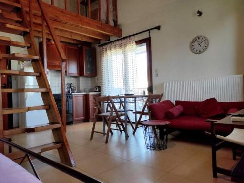 een woonkamer met een rode bank en een tafel bij Deili Studio Loft in Kalamata