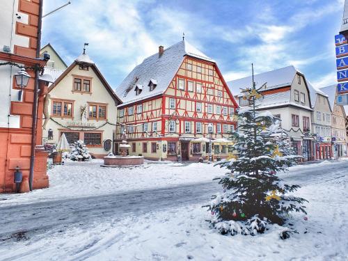 Un árbol de Navidad en medio de una calle nevada en Weekly Boardinghouse, en Lohr