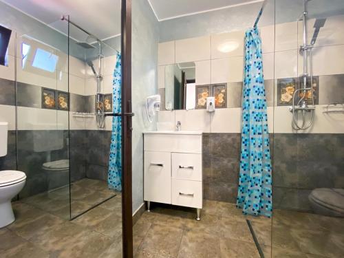 a bathroom with a shower and a sink and a toilet at Casa Mura in 2 Mai